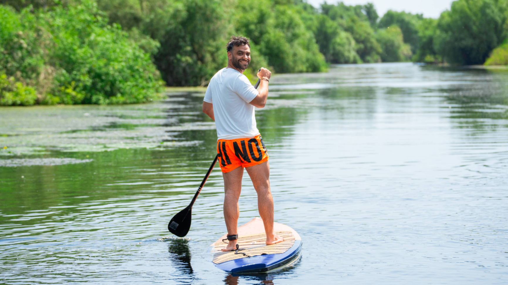 Participant on stand up paddle on a green channel