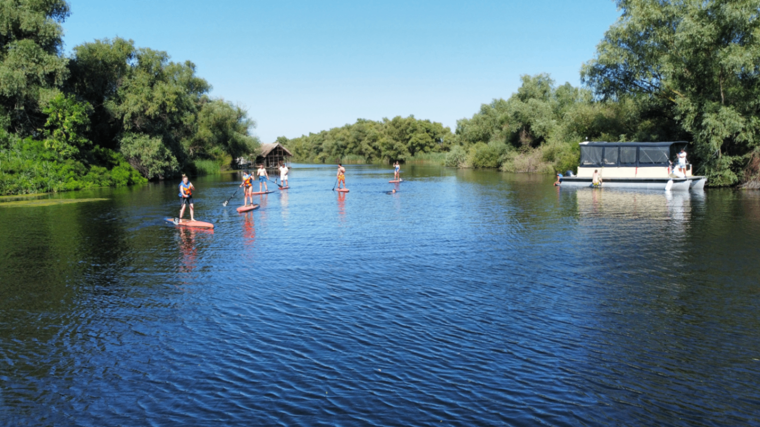 Group on SUP next to a catamaran in the Danube Delta